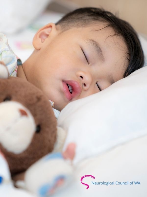 A small boy sleeping with teddy